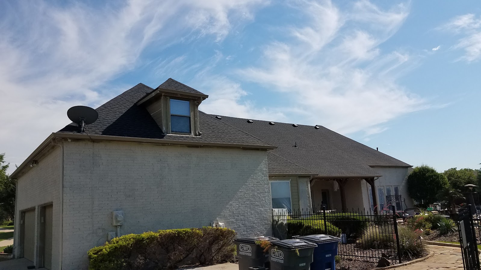 Exterior house painting during primer phase of brick painting project in mckinney texas
